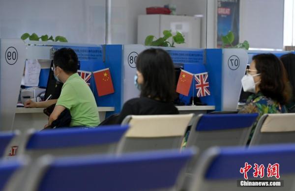 资料图：市民在位于北京的英国签证申请中心办理签证相关手续。（记者 侯宇 摄）